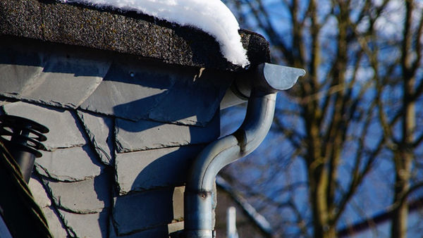 Zon smelt sneeuw op het dak